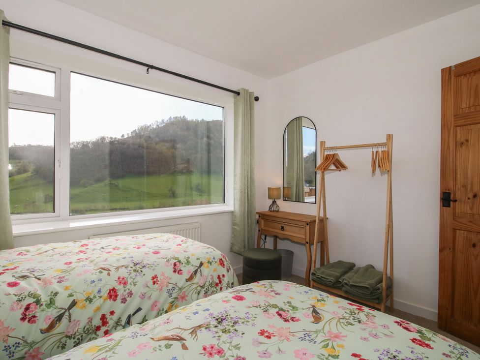 A bedroom with two beds and a dresser at Spring Bank in Llanfyllin