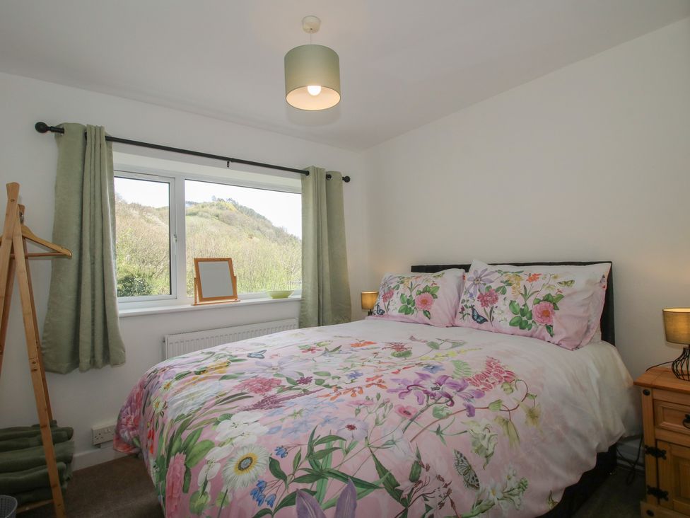 A bedroom with a bed and window at Spring Bank in Llanfyllin