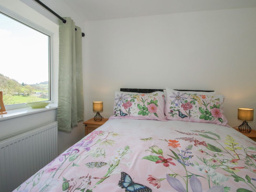 A bedroom with a bed and window at Spring Bank in Llanfyllin