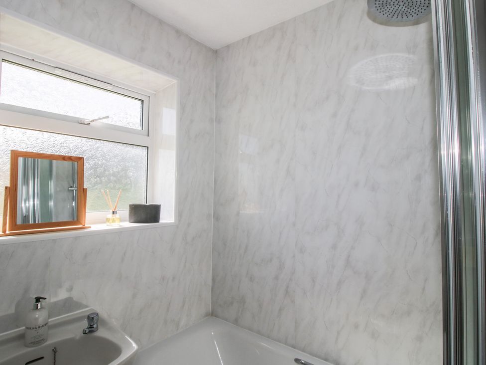 A bathroom with a bathtub and a window at Spring Bank in Llanfyllin