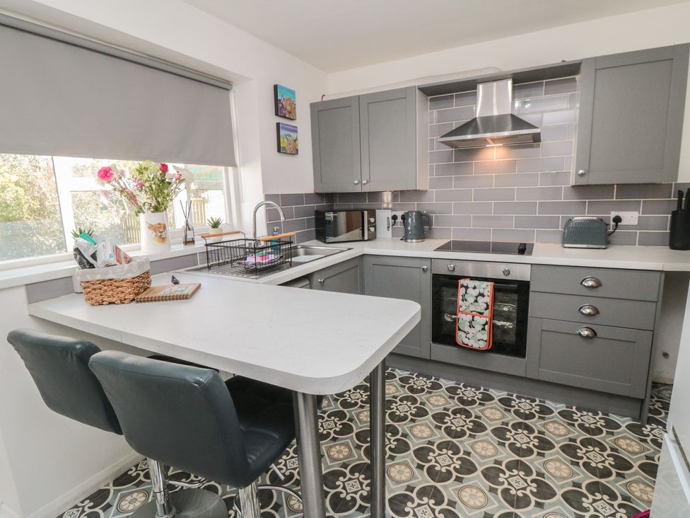 A kitchen with cabinets and appliances at Coastal Retreat in Scarborough