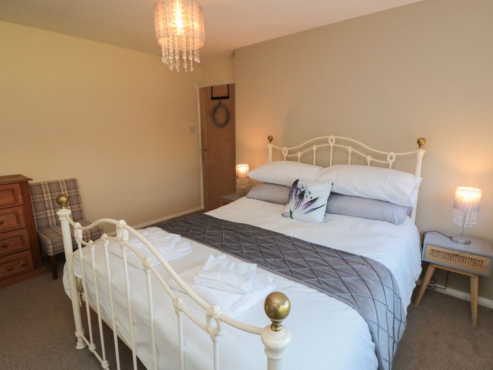 A bedroom with a bed, chair, and lamp at Coastal Retreat in Scarborough
