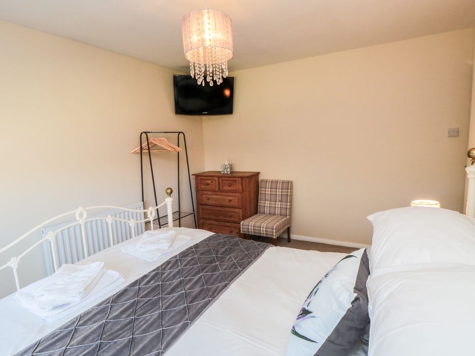 A bedroom with a bed, television, and dresser at Coastal Retreat in Scarborough