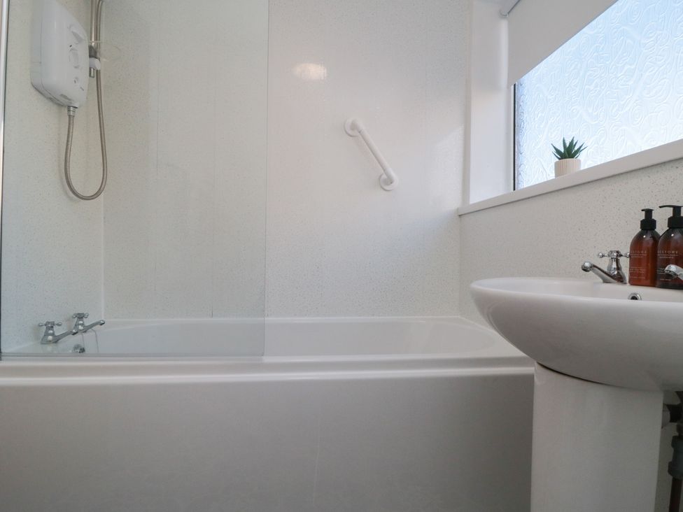 A bathroom with a bathtub and sink at Coastal Retreat in Scarborough