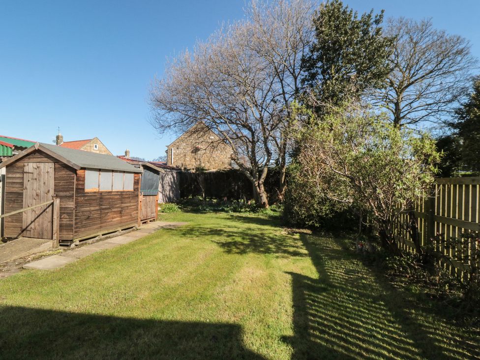 A garden with a shed and trees at Coastal Retreat in Scarborough