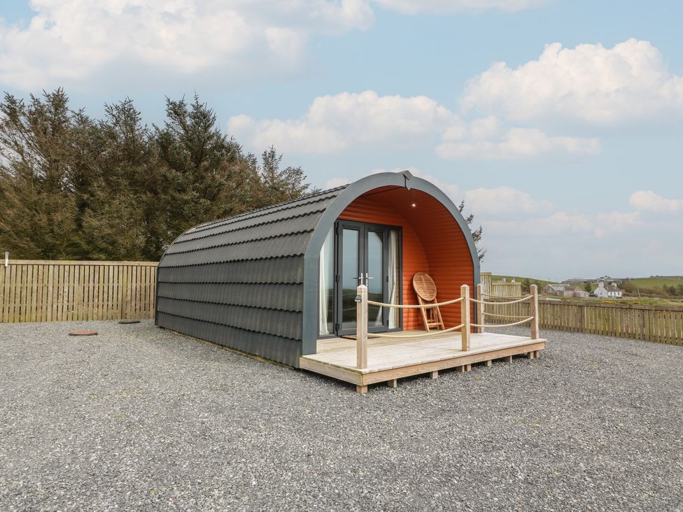 A cabin with a wooden deck in an outdoor setting at Douglas in Stoneykirk near Sandhead