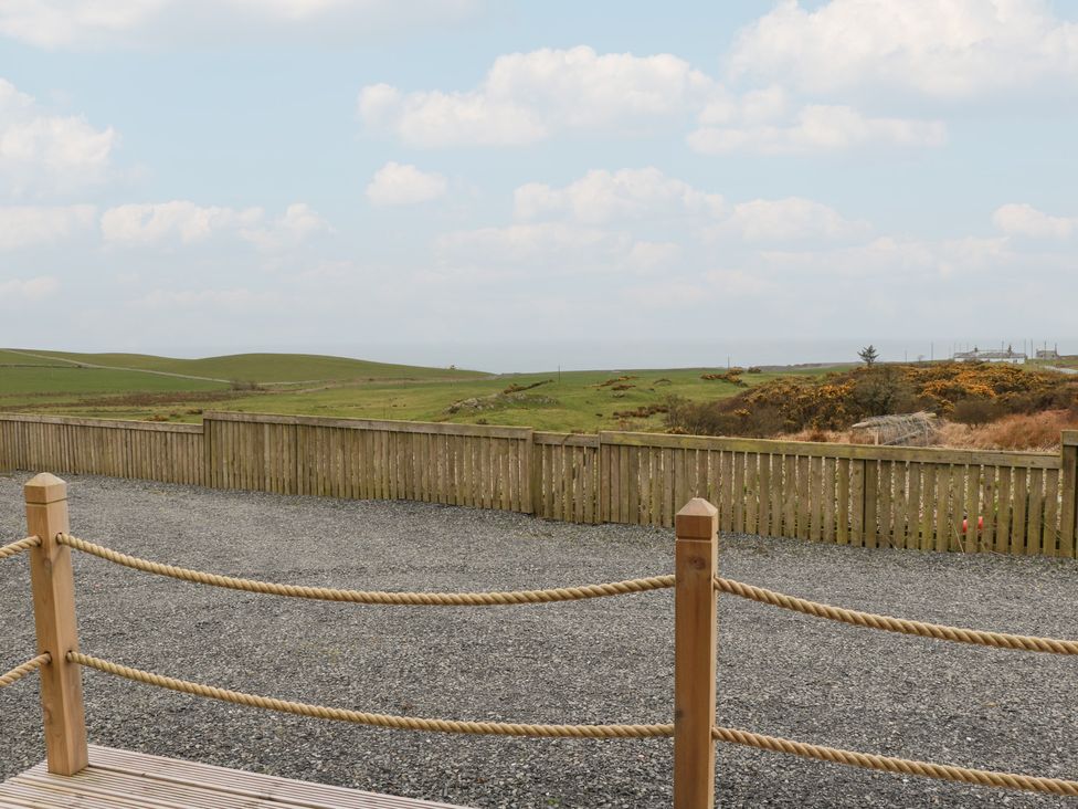 An outdoor area with a gravel path and a wooden fence at Douglas in Stoneykirk near Sandhead