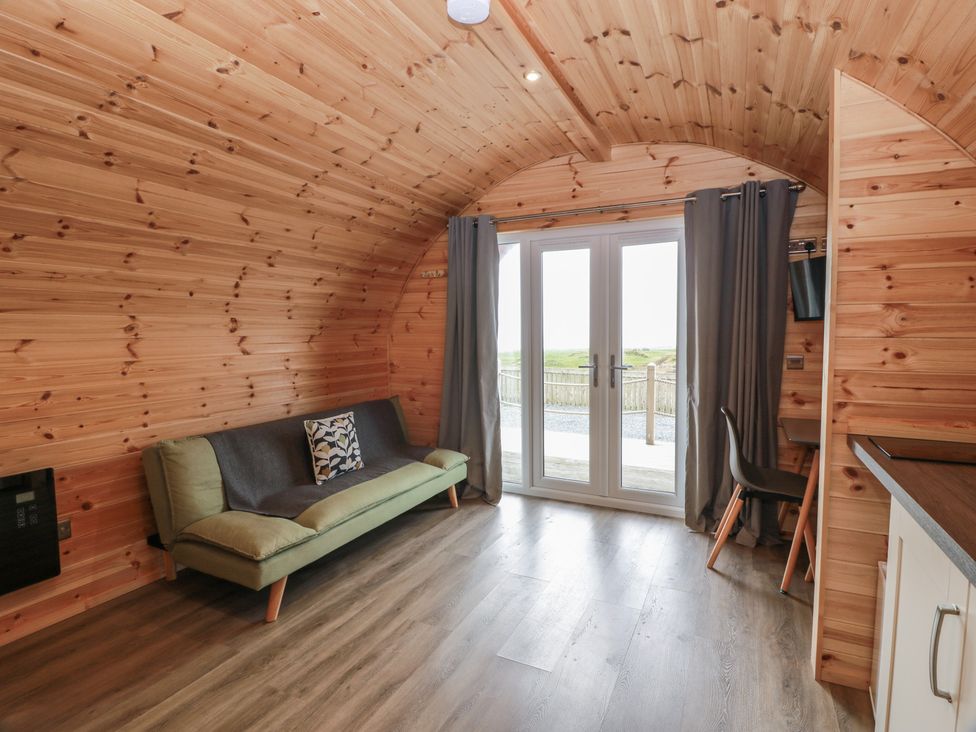 A living room with a sofa and door at Douglas in Stoneykirk near Sandhead