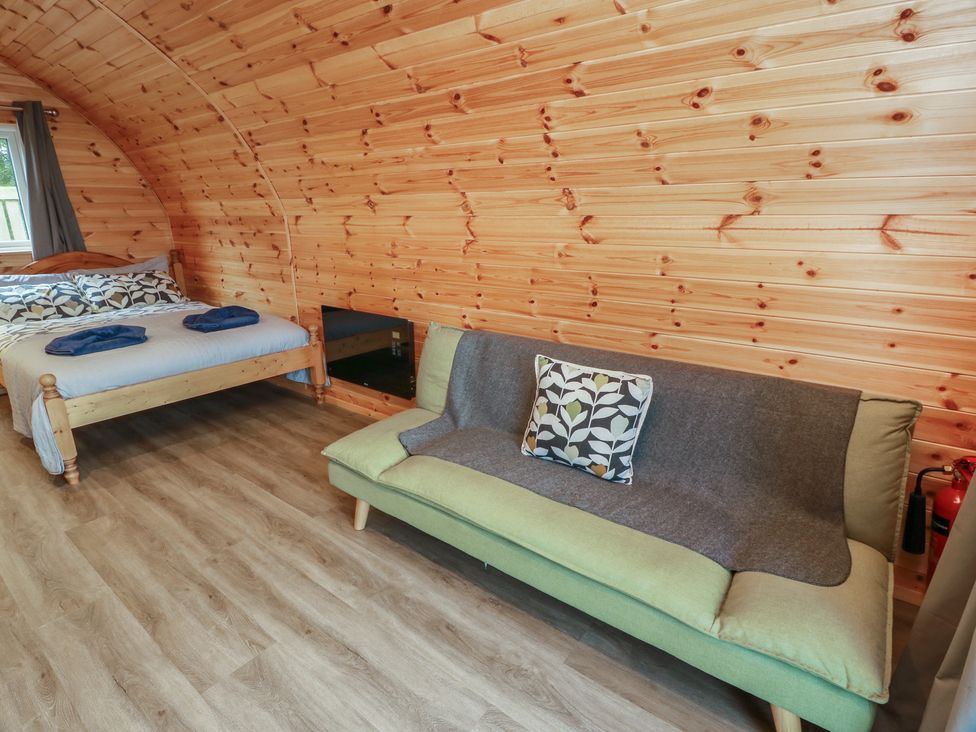 A bedroom with a bed and a sofa at Douglas in Stoneykirk near Sandhead