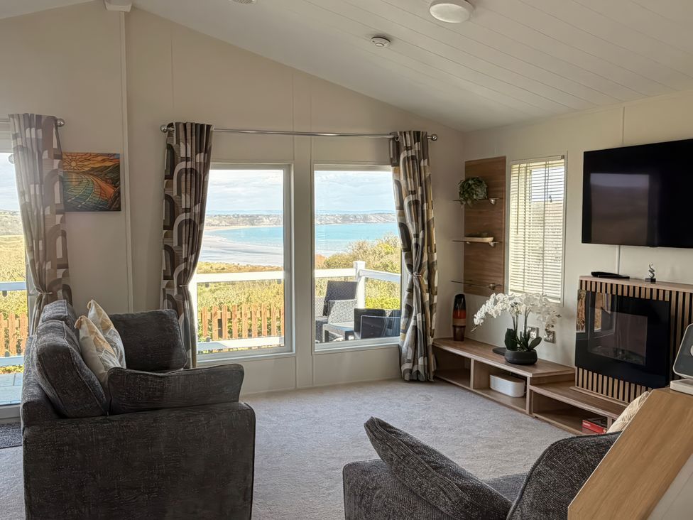 A living room with a sofa and television at Wernlas Lodge in Oxwich