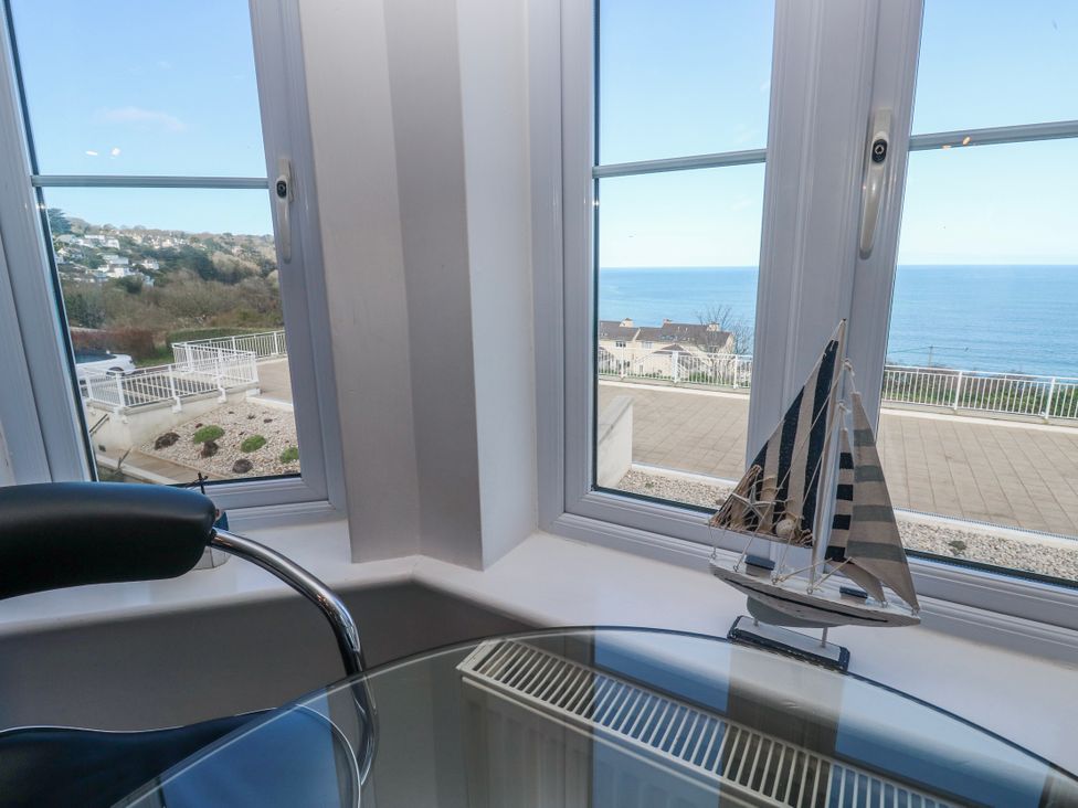 A sitting room with a boat decoration and a view of the ocean at 21 Compass Point in Carbis Bay