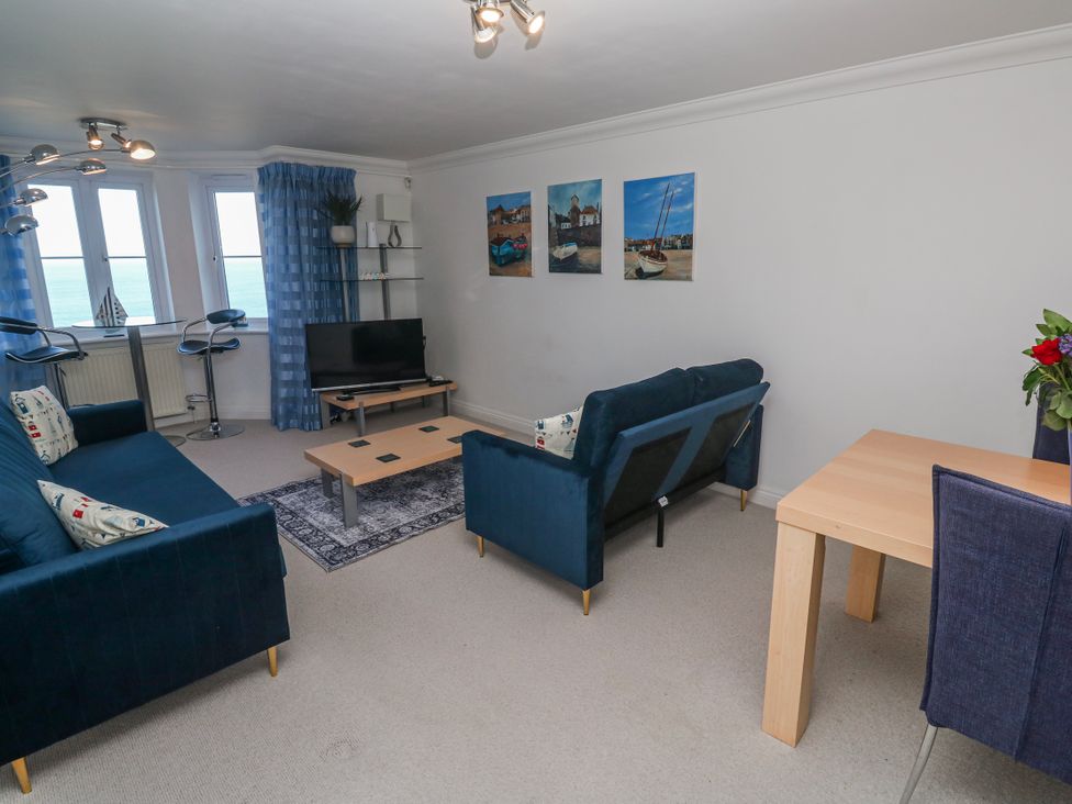 A living room with a tv and seating area at 21 Compass Point in Carbis Bay