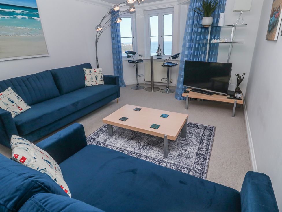 A living room with a sofa, coffee table, and television at 21 Compass Point, Carbis Bay