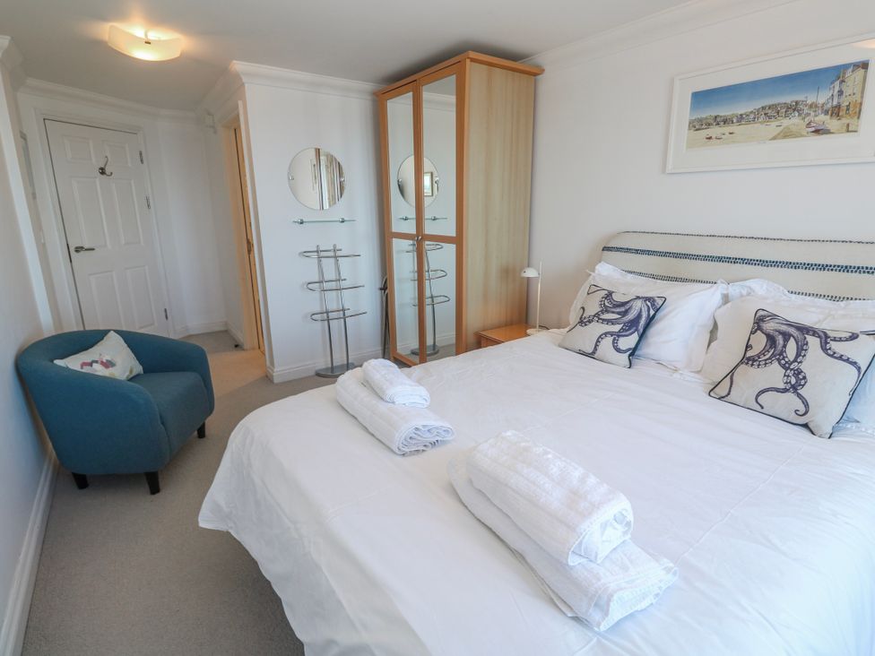 A bedroom with a bed and a chair at 21 Compass Point, Carbis Bay