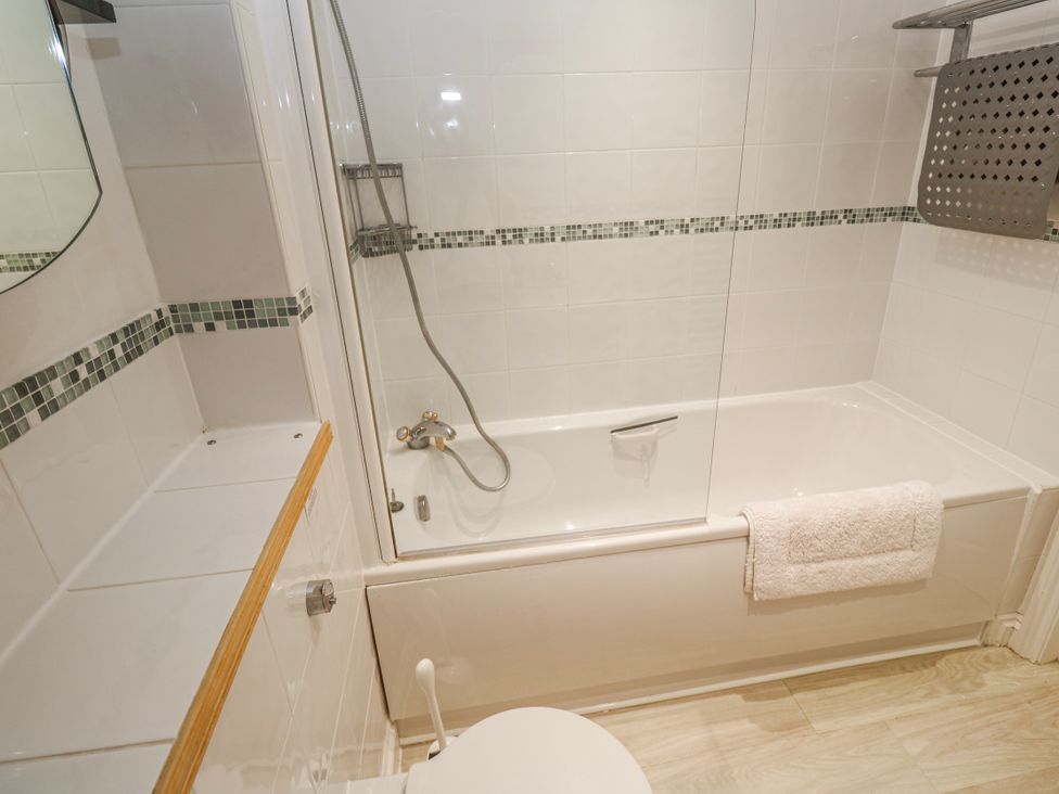 A bathroom with a bathtub and shower at 21 Compass Point in Carbis Bay