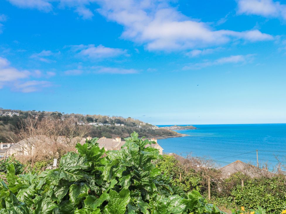 A view of the sea with clouds and houses at 21 Compass Point Carbis Bay