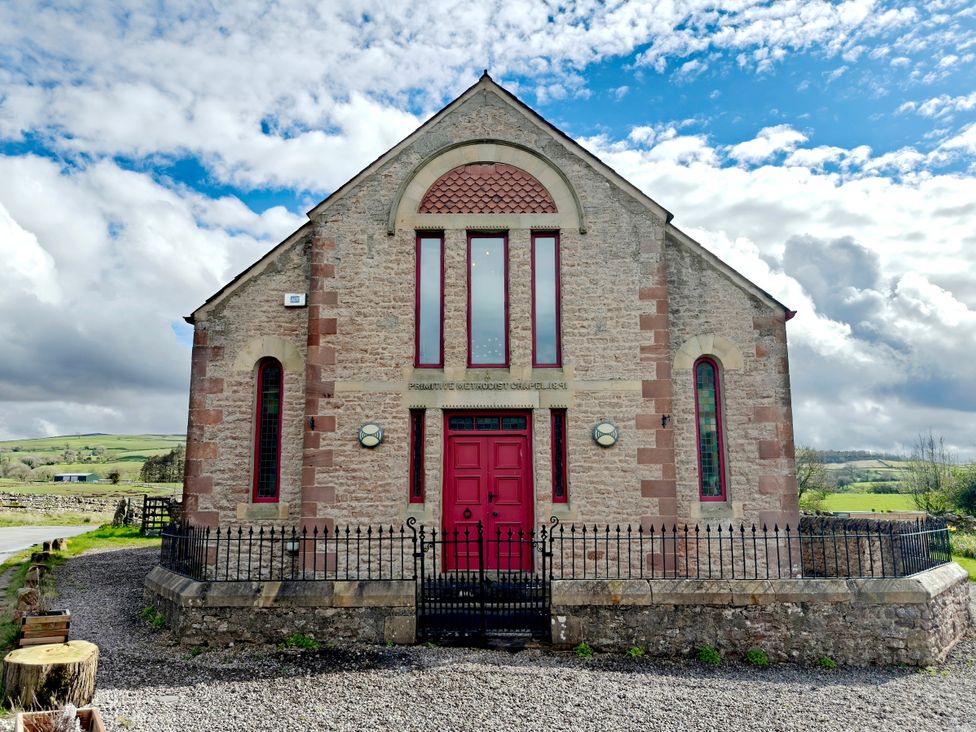 A chapel with red doors and stained glass windows at Kaber Chapel near Kirby Stephen