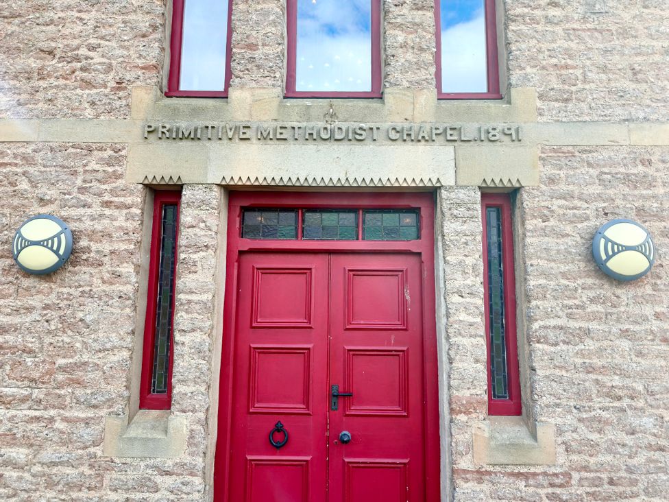 A building with a red door and windows at Primitive Methodist Chapel 1891 in Kaber near Kirby Stephen