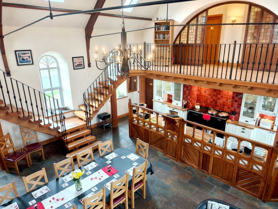 A dining room with a staircase and kitchen area at Kaber Chapel Kaber near Kirby Stephen