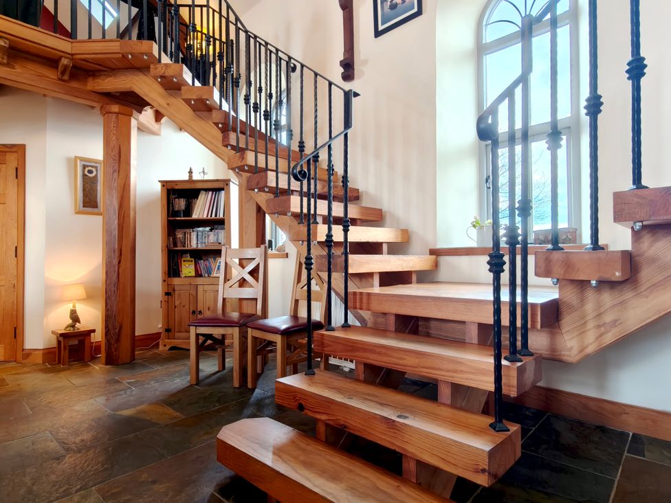 An entrance hall with a staircase and bookshelf at Kaber Chapel in Kaber near Kirby Stephen