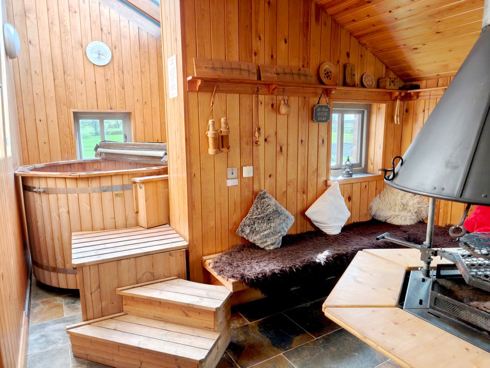 An indoor area with a wooden hot tub and seating at Kaber Chapel in Kaber near Kirby Stephen