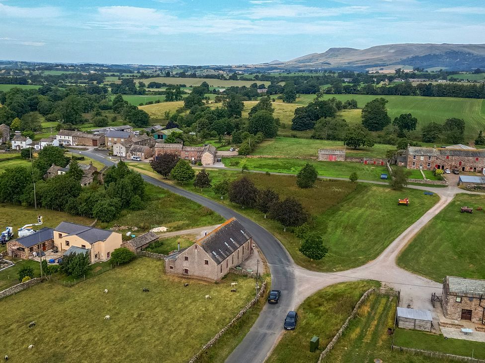An aerial view of a rural area with houses and fields near Kaber Chapel in Kaber near Kirkby Stephen