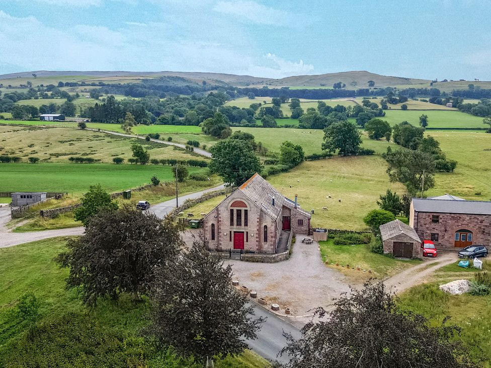 A building and cars near fields at Kaber Chapel in Kaber near Kirkby Stephen