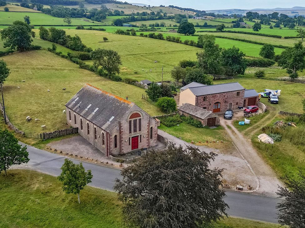 An aerial view of a building and vehicles in a field at Kaber Chapel near Kirkby Stephen
