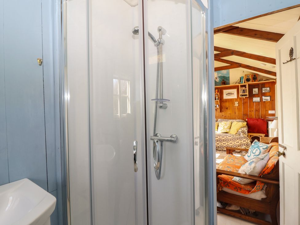 A shower and toilet leading to a living area at The Cabin 