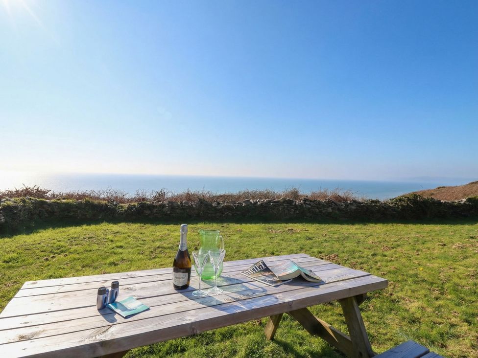 A table with drinks and a magazine overlooking the sea at The Cabin