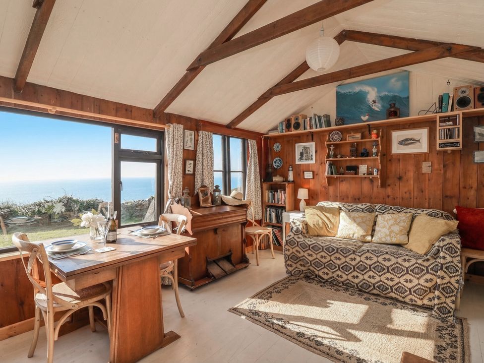 A living room with a dining table and sofa at The Cabin