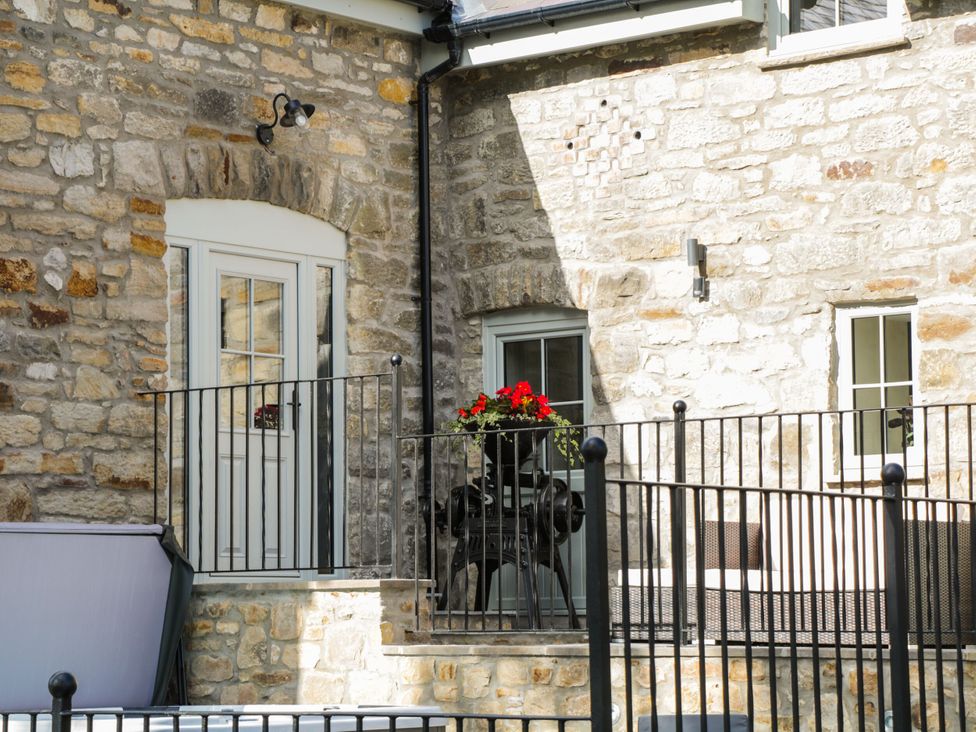 An outdoor area with a stone wall and a planter at Sun Trevor Barns 2 Llangollen