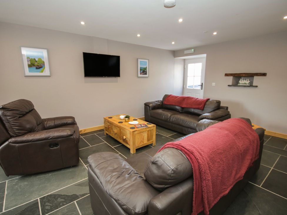 A living room with sofas and a television at Sun Trevor Barns 2 Llangollen