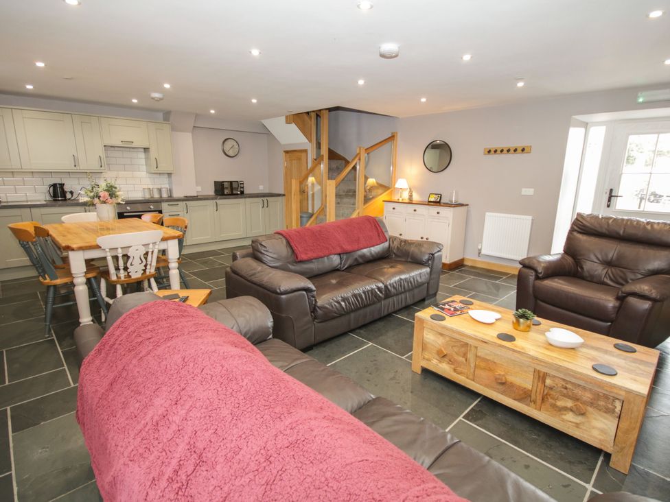 A living room with sofa and dining area at Sun Trevor Barns 2 Llangollen