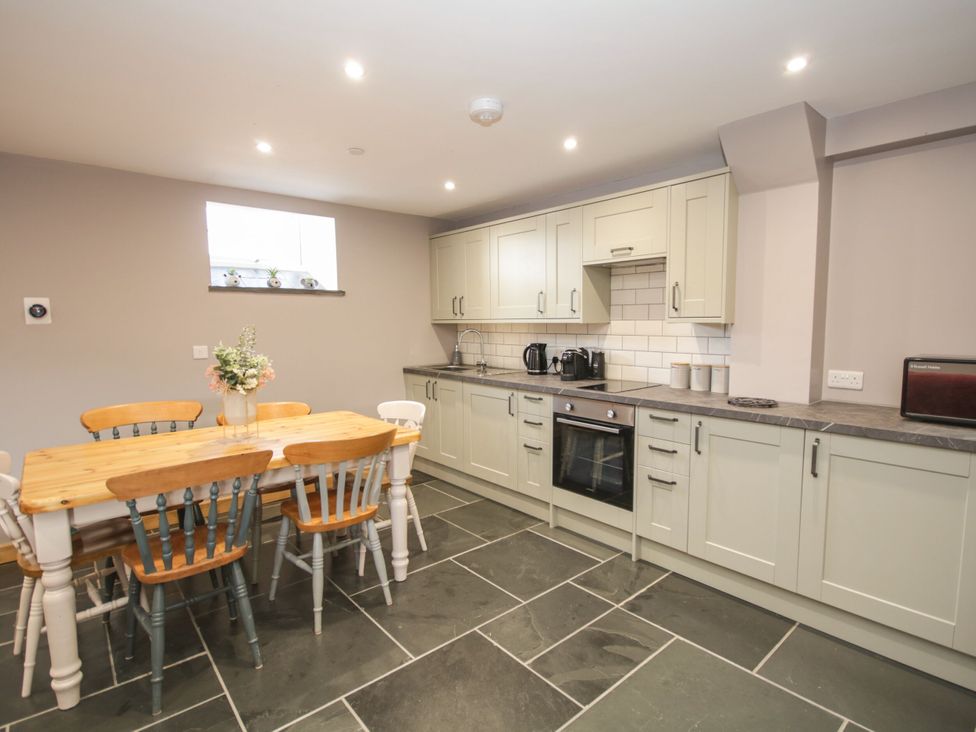 A kitchen with a table and chairs at Sun Trevor Barns 2 Llangollen