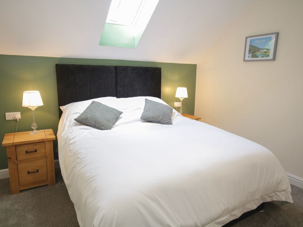 A bedroom with a bed and bedside tables at Sun Trevor Barns 2 Llangollen