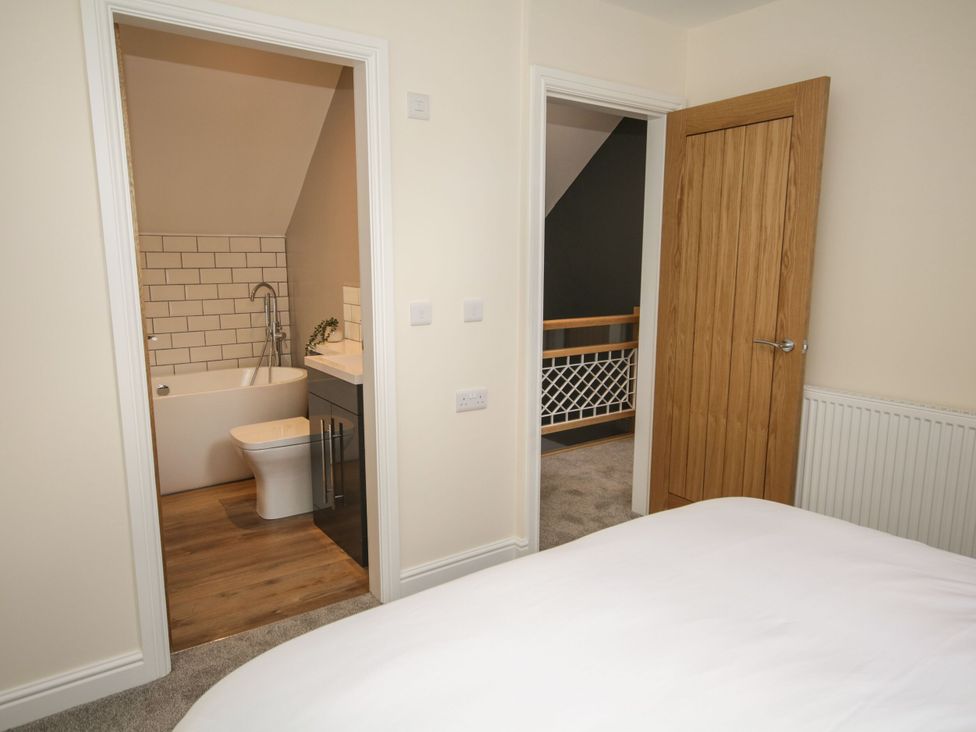 A bedroom view with bathroom and stairs at Sun Trevor Barns 2 Llangollen