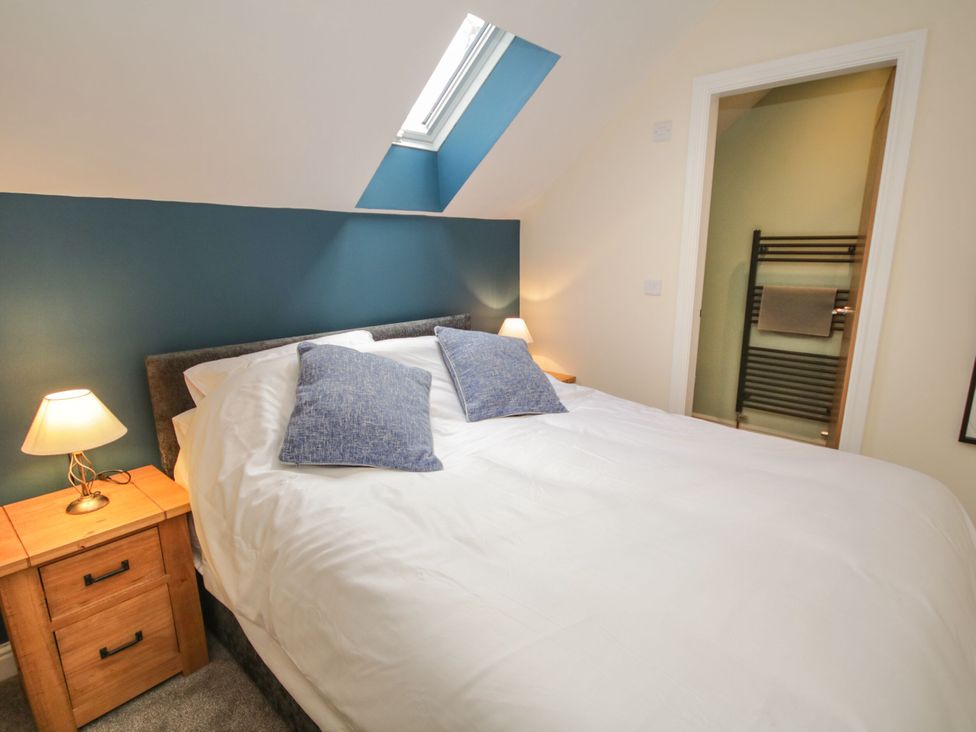 A bedroom with a bed and nightstand at Sun Trevor Barns 2 in Llangollen