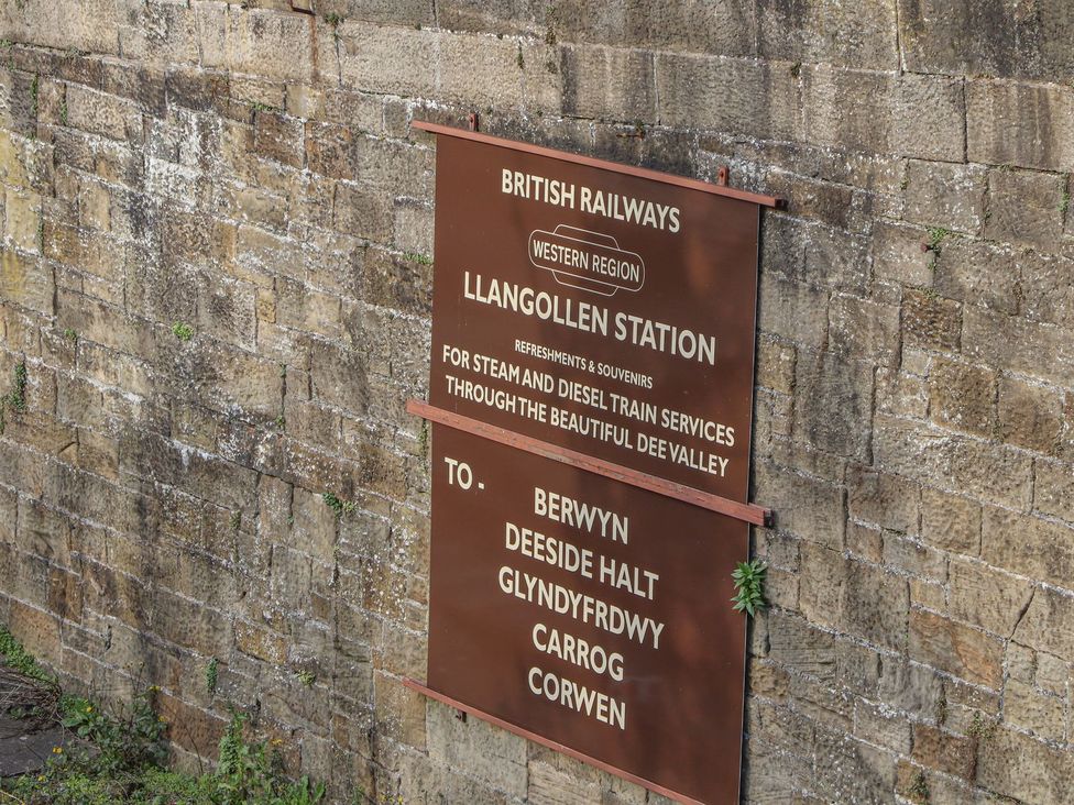 A sign for Llangollen Station showing train services in Llangollen