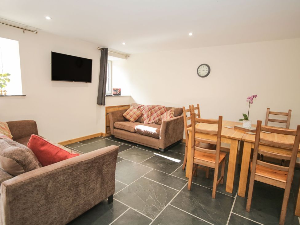 A living room with a sofa and dining table at Sun Trevor Barns 3 in Llangollen