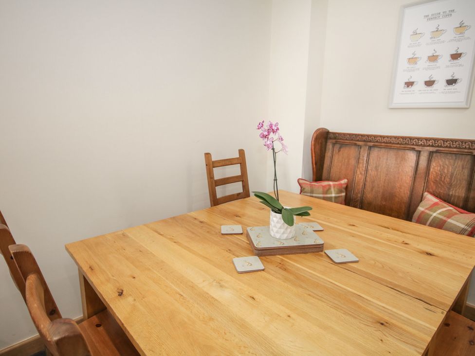 A dining room with a wooden table and chairs at Sun Trevor Barns 3 Llangollen