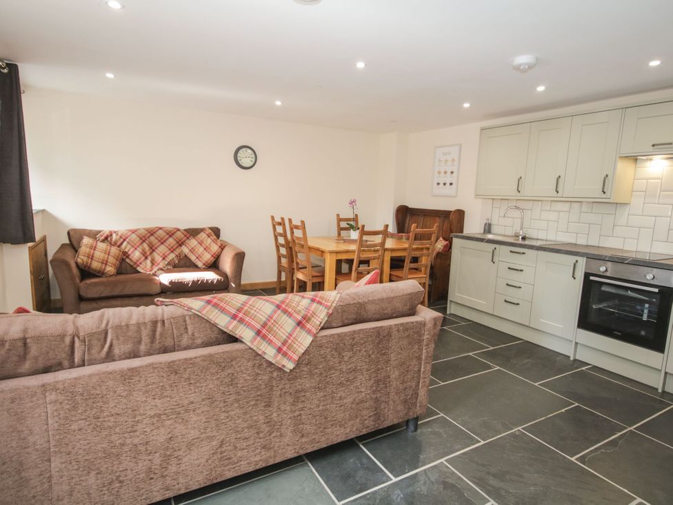 A kitchen with a dining area and sofa at Sun Trevor Barns 3 in Llangollen