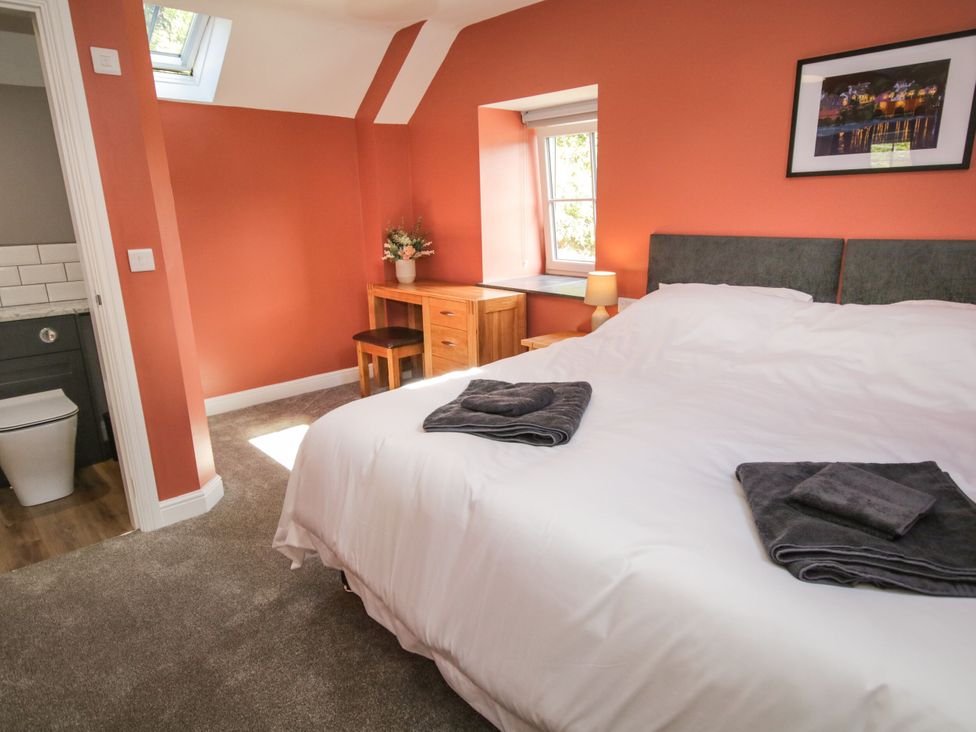 A bedroom with a bed and a desk at Sun Trevor Barns 3 Llangollen