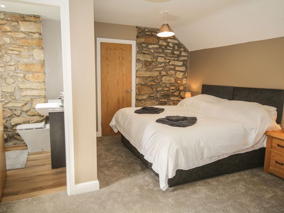 A bedroom with a bed and ensuite bathroom at Sun Trevor Barns 3 Llangollen