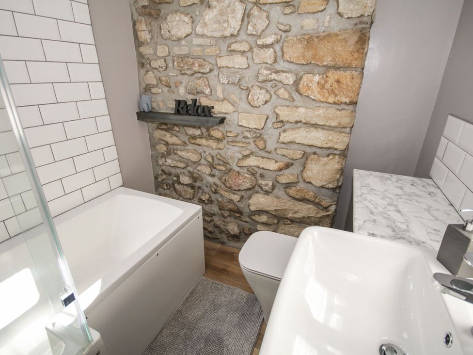 A bathroom with a bathtub and sink at Sun Trevor Barns 3 in Llangollen