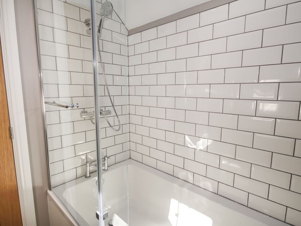 A bathroom with a bathtub and shower at Sun Trevor Barns 3 in Llangollen