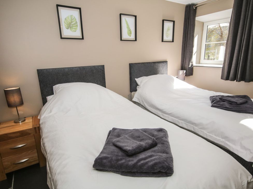 A bedroom with two beds and a lamp at Sun Trevor Barns 3 Llangollen