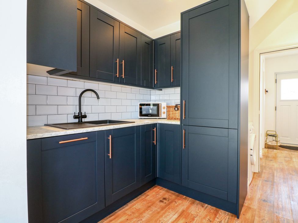 A kitchen with cabinets, sink, and microwave at 19 Berry Avenue in Breedon On The Hill