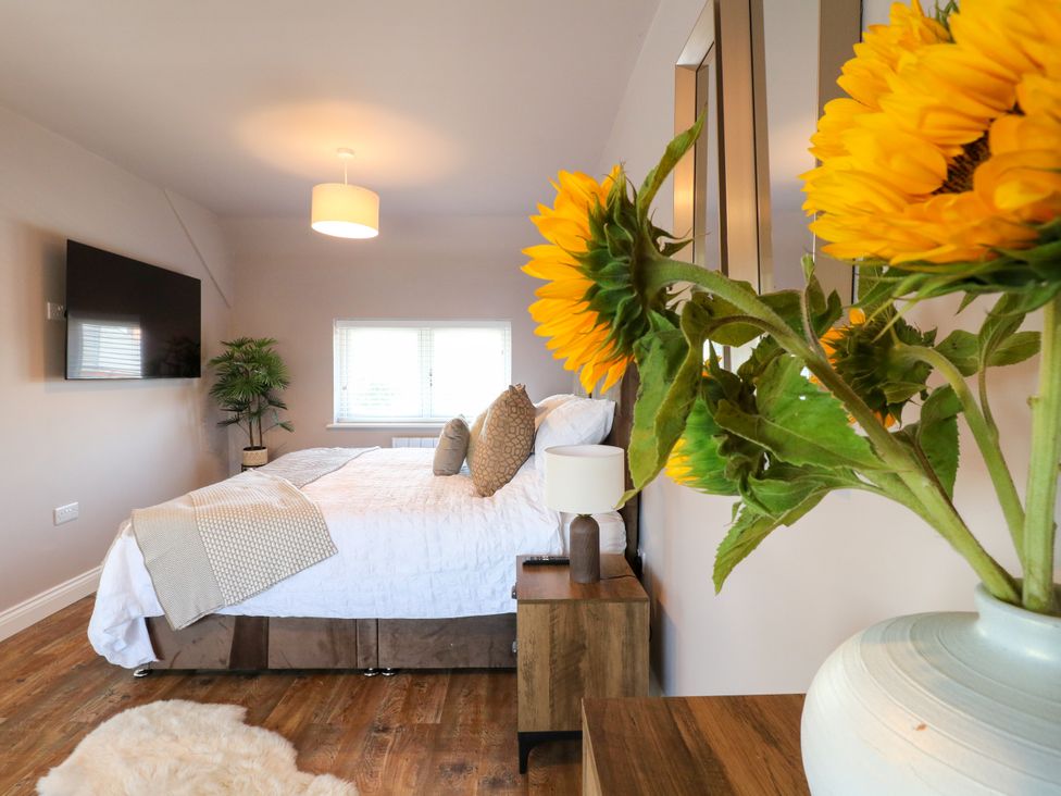 A bedroom with a bed and television at 19 Berry Avenue in Breedon On The Hill