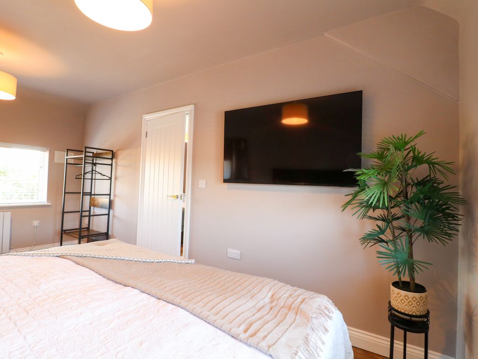 A bedroom with a bed and a television at 19 Berry Avenue in Breedon On The Hill
